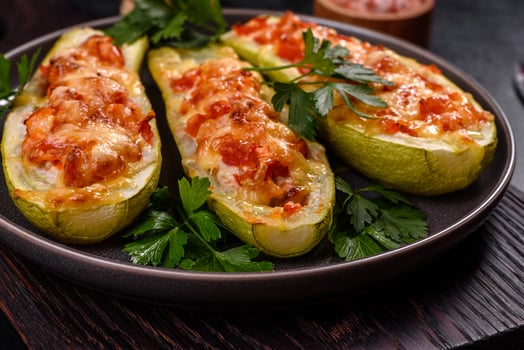 Baked stuffed zucchini boats with minced chicken mushrooms and vegetables with cheese photo