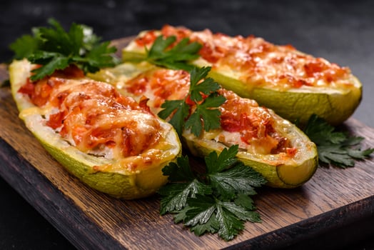 Baked stuffed zucchini boats with minced chicken mushrooms and vegetables with cheese photo