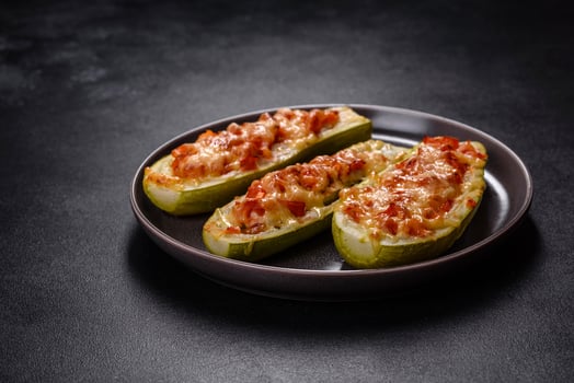 Baked stuffed zucchini boats with minced chicken mushrooms and vegetables with cheese photo