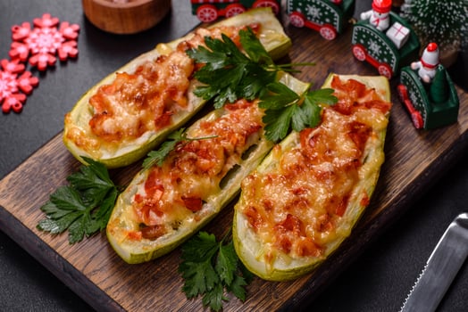 Baked stuffed zucchini boats with minced chicken mushrooms and vegetables with cheese. Christmas table photo