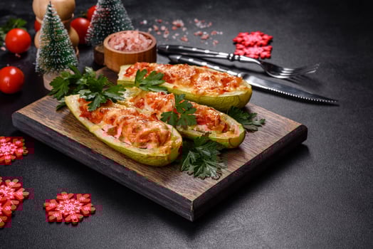 Baked stuffed zucchini boats with minced chicken mushrooms and vegetables with cheese. Christmas table photo