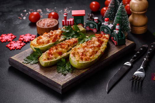 Baked stuffed zucchini boats with minced chicken mushrooms and vegetables with cheese. Christmas table photo