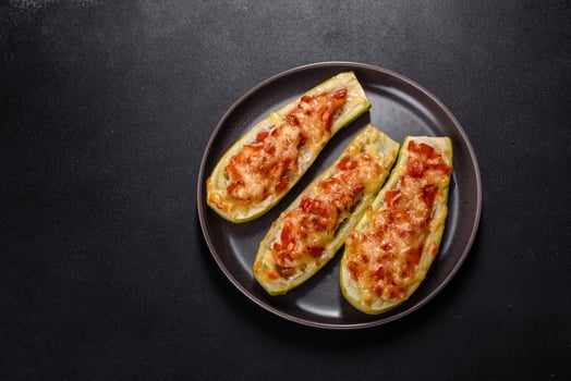 Baked stuffed zucchini boats with minced chicken mushrooms and vegetables with cheese photo