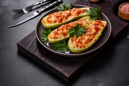 Baked stuffed zucchini boats with minced chicken mushrooms and vegetables with cheese photo