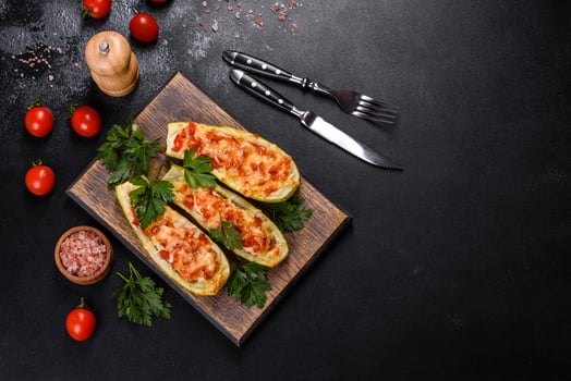 Baked stuffed zucchini boats with minced chicken mushrooms and vegetables with cheese photo
