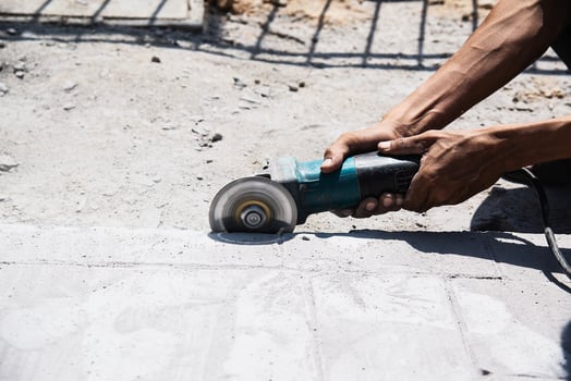 Man doing concrete floor or road finishing using hand grinding machine photo