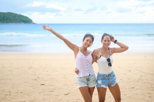 Two attractive women friends enjoying and relaxing on the beach,  Summer, vacation, holidays, Lifestyles concept. photo