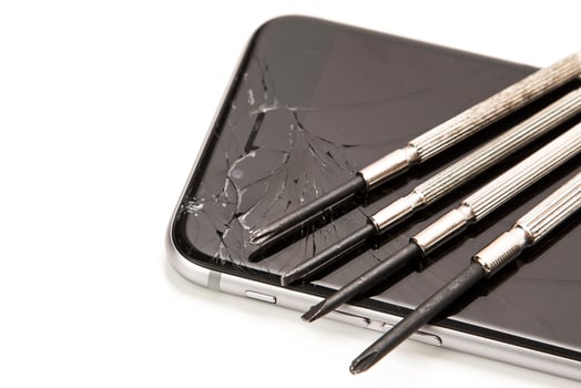 Broken smartphone and small screwdrivers for repair photo