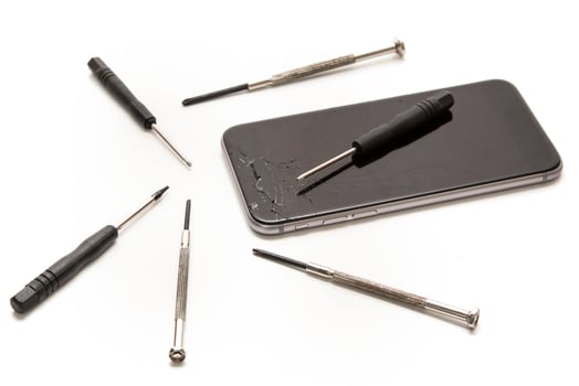 Broken smartphone and small screwdrivers for repair photo