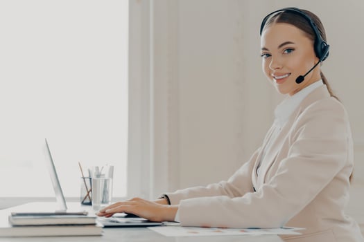 Smiling call center agent in headset consulting client photo