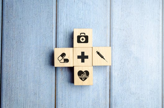 Health insurance concept, wooden blocks with healthcare medical icon, blue background photo