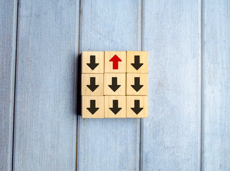 Wooden block with red arrow facing the opposite direction black arrows photo