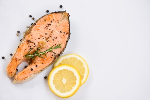 Grilled salmon steak with herbs and spices rosemary lemon on plate background Close up cooked salmon fish fillet steak seafood photo