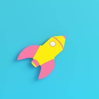 Yellow cartoon styled rocket on bright blue background in pastel colors photo