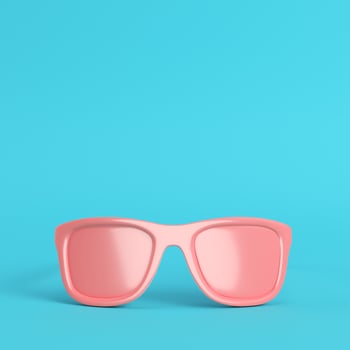 Red sun glasses on bright blue background in pastel colors with copy space photo