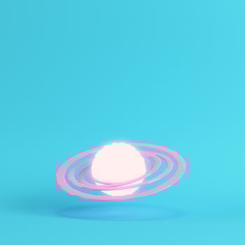 Pink abstract glowing planet with rings on bright blue background in pastel colors photo