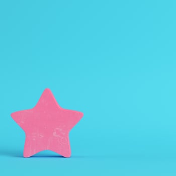 Pink abstract star on bright blue background in pastel colors photo