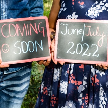 Indian couple posing for maternity baby shoot. The couple is posing in a lawn with green grass and the woman is falunting her baby bump in Lodhi Garden in New Delhi, India photo