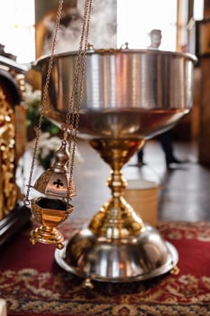 selective focus. A priest's censer hangs on an old wall in the Orthodox Church. Copper incense with burning coal inside. Service in the concept of the Orthodox Church. Adoration photo