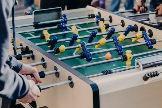 Male friends have unforgettable time together, play table football or kricker, have fun, want to have victory. Close up image of plastic colourful players photo