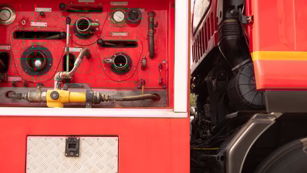 Gauge pressure and valve lever with high pressure fire safety pump on side view of red fire truck photo
