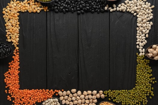 Legumes, overhead flat lay shot on a dark rustic wooden background with a place for text photo