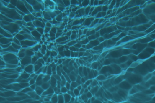Defocus blurred blue watercolor in swimming pool rippled water detail background. Water splash, water spray background. photo