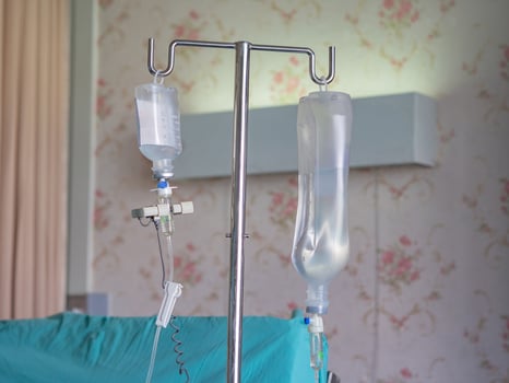 Saline solution hanging for patient in ward room. Health care concept photo