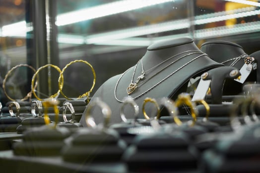 Gold jewelry diamond shop with rings and heart shape necklaces in luxury retail store photo