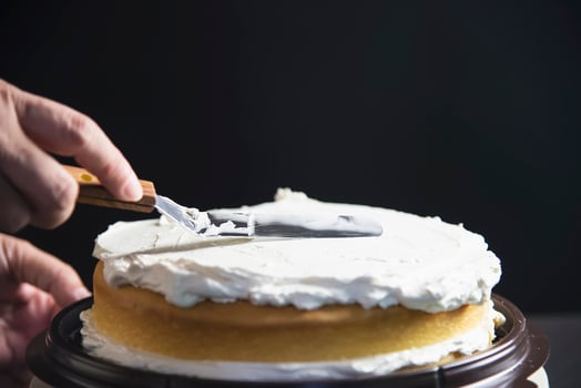 Lady making cake putting cream using spatula - homemade bakery cooking concept photo