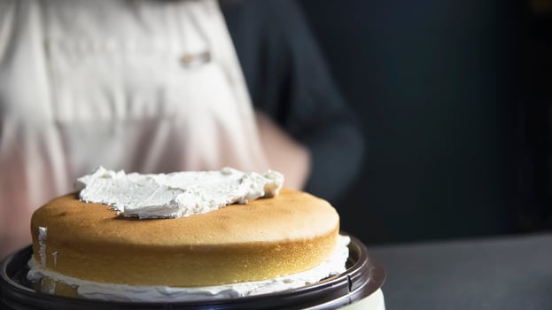 Lady making cake putting cream using spatula - homemade bakery cooking concept photo