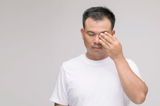 Eye irritation concept, Portrait of Asian man in posture of eye tired,  irritation or problem about his eye. Studio shot isolated on grey photo