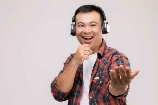 Portrait Asian man listening song or music from black headphone. Studio shot isolated on grey photo