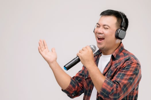Portrait Asian man listening song or music from black headphone. Studio shot isolated on grey photo