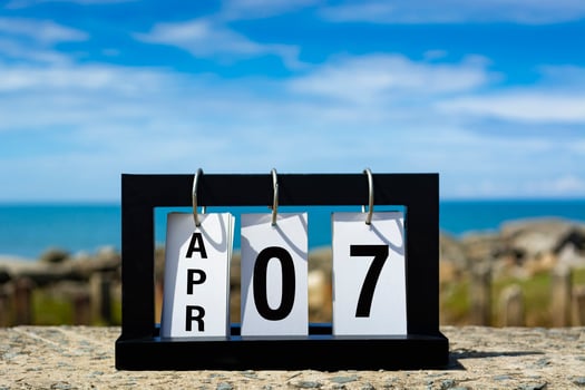 Apr 07 calendar date text on wooden frame with blurred background of ocean. photo