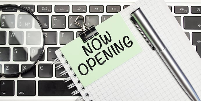 NOW OPENING word on the green paper with office tools on white background photo