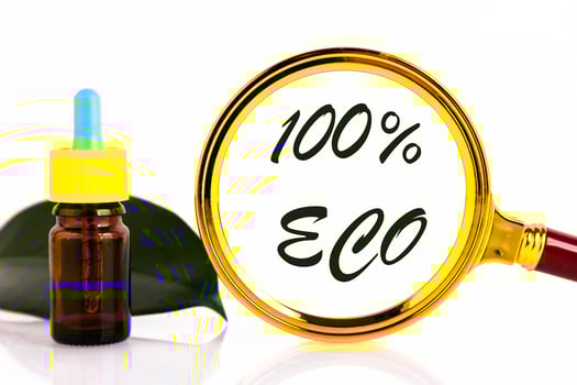 Blank amber glass essential oil bottle with pipette on green leaves background. One hundred percent ECO. Copy space photo