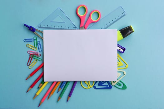 Top view of school supplies and office supplies on blue background. Learning, study, office equipment and presentation concept. photo