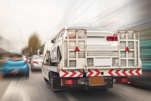 Broken car on tow truck after traffic accident, on the road service photo