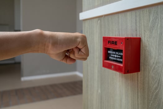 Fire alarm box with human hand action to crush the glass for emergency situation. photo