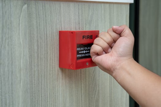 Fire alarm box with human hand action to crush the glass for emergency situation. photo