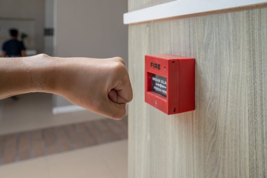 Fire alarm box with human hand action to crush the glass for emergency situation. photo