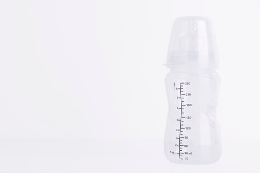 Baby feeding bottle with pacifier on a white background. Copy space. photo
