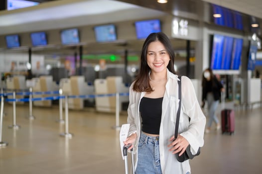 Young female traveler carrying suitcases at the International airport, travel, holidays and journey concept. photo
