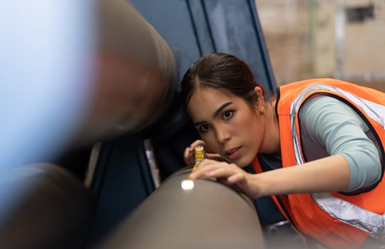 Portrait of an Asian woman with large machinery used in heavy industrial plants. photo