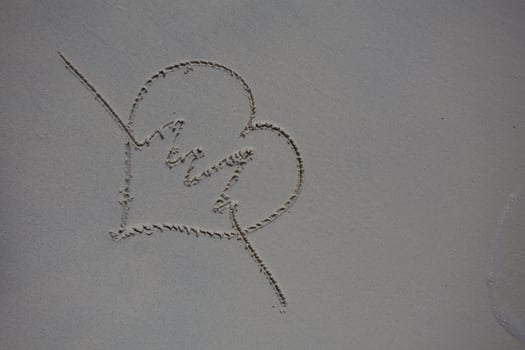 hearts drawn on the sand of a beach photo