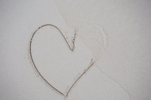 hearts drawn on the sand of a beach photo