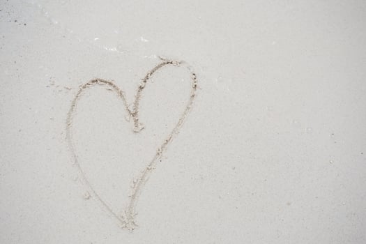 hearts drawn on the sand of a beach photo