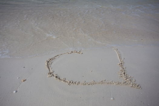 hearts drawn on the sand of a beach photo