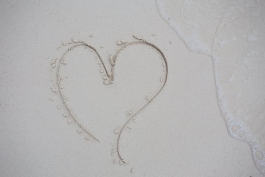 hearts drawn on the sand of a beach photo